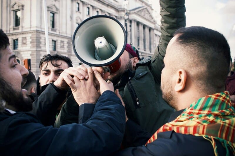 Manifestación de hombres con un megáfono en la vía pública