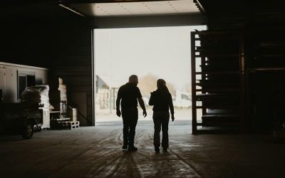 Dos personas a contraluz caminando en un galpón