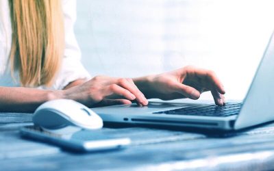 manos de mujer tecleando en una notebook