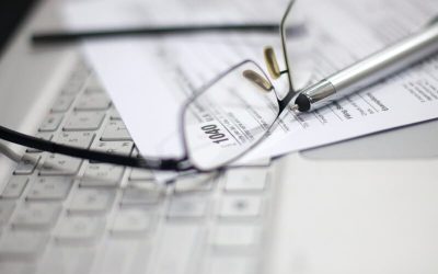 Anteojos papeles y teclado de computadora