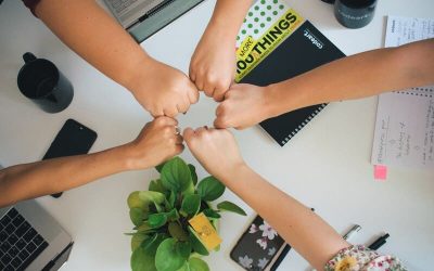 puños de mujeres unidos sobre un escritorio