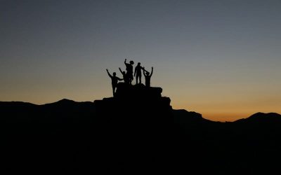 grupo de gente sobre la cima de una montaña