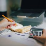 manos en escritorio con calculadora