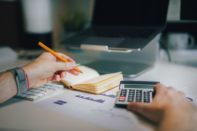 manos en escritorio con calculadora