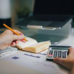Escritorio con calculadora y manos